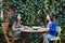 Friends and Coffee: Cafe Patio with lush foliage Hosts Two Young Latina Women Enjoying Coffee and Sweet Pastries