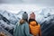 Friends or couple embracing against snow capped mountains in winter
