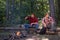 Friends couples enjoy vacation or weekend forest. Happy friends on a camping trip relaxing by campfire. Company two male