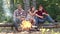 Friends couples enjoy vacation or weekend forest. Weekend hike. Young people enjoying picnic in park on summer day