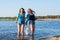 Friends are dancing and splash water on a seashore, laughing. Two women, students are happy on the beach