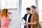 Friends doing paperwork and woman putting document on flipchart