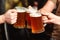 Friends drinking beer at pub. Toast for beer. Men hands raising toast with cold beer mugs at bar