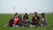 Friends enjoy fine weather and eat sandwiches on a picnic near wind generators