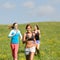 Friends enjoy running through sunny meadow