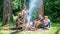 Friends enjoy summer vacation or weekend forest. Summer vacation. Company friends relaxing near campfire. Pleasant