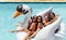 Friends enjoying on a inflatable swan in pool