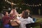 Friends and family making a toast at dinner party in garden