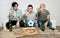 Friends fanatic football fans watching tv match with beer bottles and pizza suffering stress