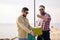 Friends with fish, bucket and fishing rod on pier