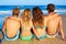 Friends group couples sitting in beach sand rear