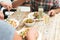 Friends having dinner with salad, olives and champagne on wooden table outdoor