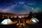 Friends hikers sitting beside camp and tents in the night