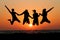 Friends jumping in sunset at beach