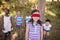 Friends looking at blindfolded girl standing in forest