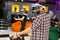 Friends, a man and a woman use a virtual reality headset with glasses and hand motion controllers in the play area