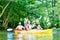 Friends paddling with canoe on forest river