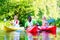 Friends paddling with canoe on river