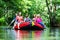 Friends paddling on rubber boat at forest river