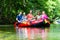 Friends paddling on rubber boat at forest river