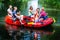 Friends paddling on rubber boat at forest river or creek