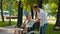 Friends in park - a guy talking with disabled woman in a wheelchair