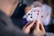 Friends are playing cards together at home. Man is holding cards in her hands, woman in the blurry background