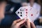 Friends are playing cards together at home. Man is holding cards in her hands, woman in the blurry background