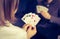 Friends are playing cards together at home. Woman is holding cards in her hands, man in the blurry background