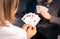 Friends are playing cards together at home. Woman is holding cards in her hands, man in the blurry background