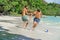 Friends playing footbal at the sunny tropical beach