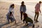 Friends Playing Noughts And Crosses In Sand On Winter Beach