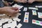 Friends playing to a strategy game board on a table. Blocks of number and statistic for score and win in a tabletop at home. Hands