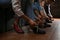 Friends putting shoes on at n bowling, closeup of legs