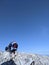 Friends Reaching to the Deep Blue Sky on a Mountaintop