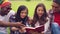 Friends reading book together outdoors