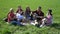 Friends rest on a picnic with food and refreshing drinks