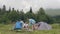 Friends resting in summer camping. People resting near camping tent in forest