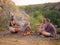 Friends roasting marshmallows near a fireplace on a natural background. Picnic day concept. Copy space.