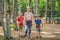 Friends on the ropes course. Young people in safety equipment are obstacles on the road rope