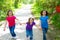 Friends and sister girls running in the forest track happy