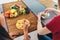 Friends sit at table, talk and eat vegetables by hands.