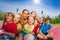 Friends sit on volleyball game court holding ball