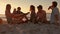 Friends sitting at the beach and playing guitar