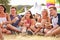 Friends sitting on the grass eating at a music festival