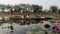 friends sitting on a rowboat, in the middle of the pond with pink lotus flowers.