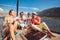 Friends sitting on sailboat deck and having fun.Vacation, travel, sea, friendship and people concept