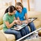 Friends sitting on sofa looking at photographs