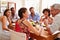 Friends sitting at a table talking during a dinner party