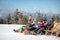 Friends skiers relax in chairs on the mountain top